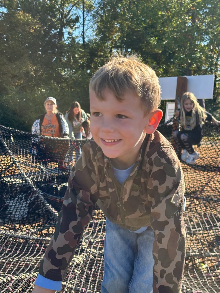 A smiling boy on the WEE Center playground on a sunny day