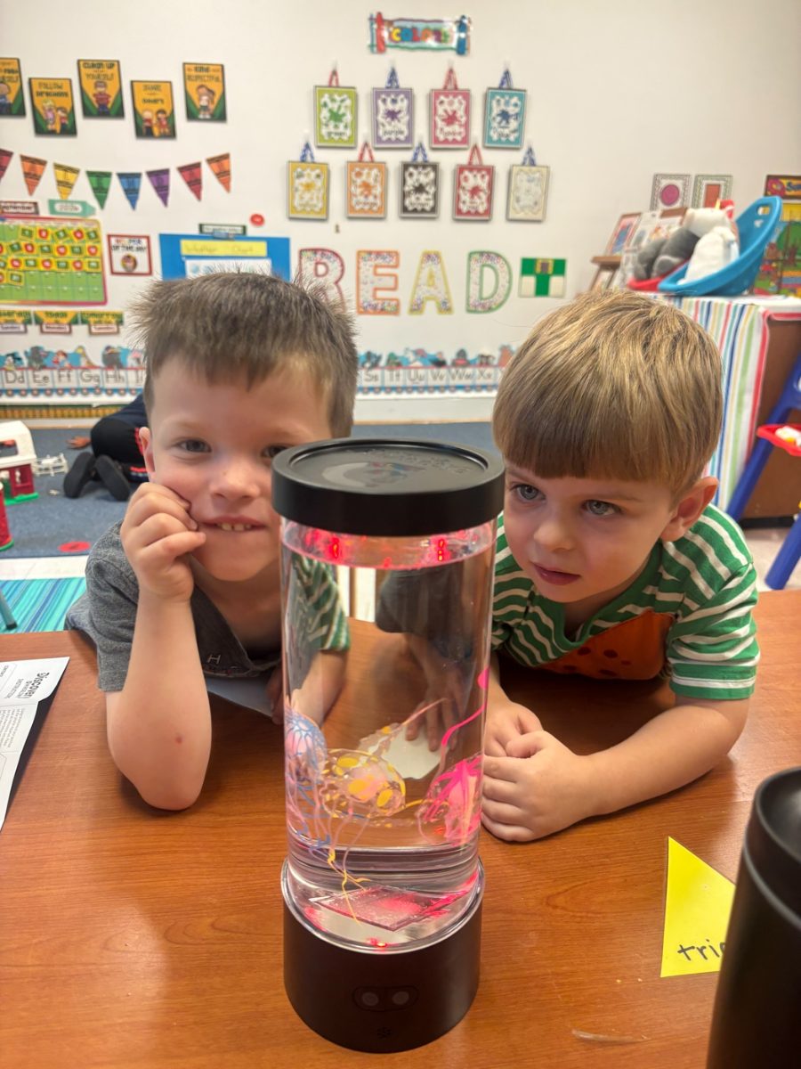 Two preschool boys observing a sensory jar in a WEE Center classroom